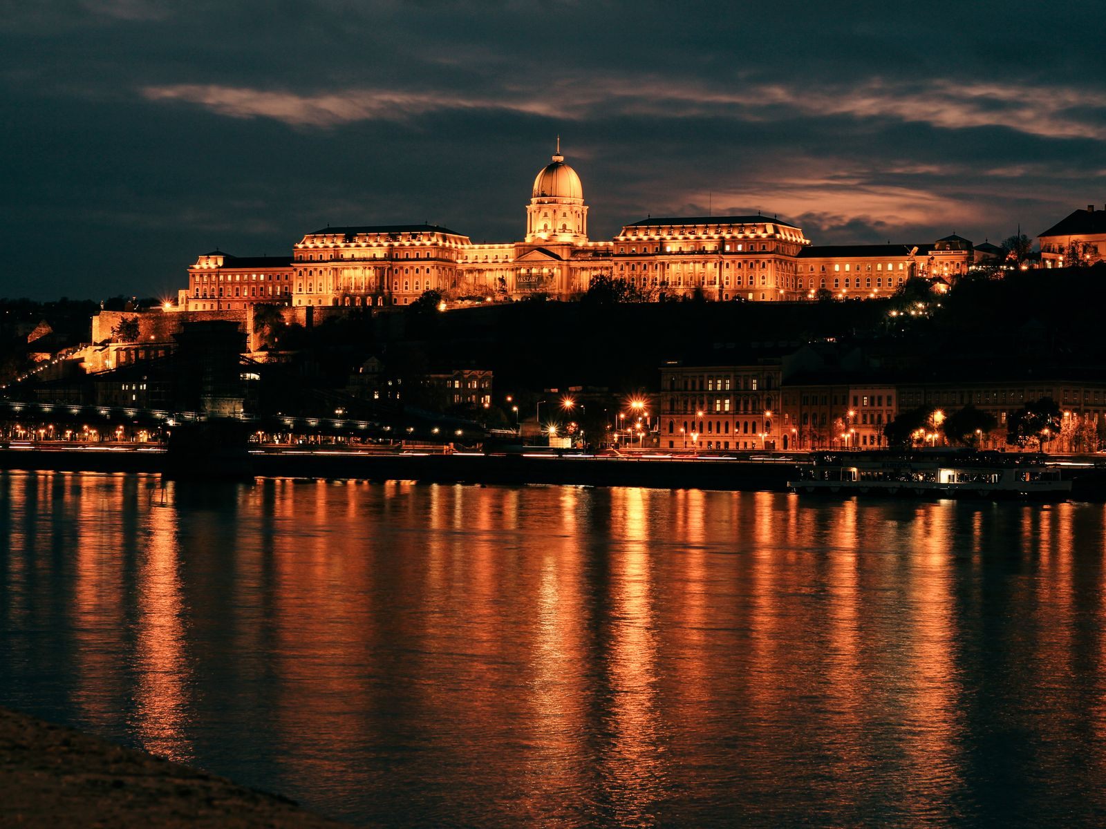 Buda Castle lit at night above the Danube in Budapest, a port on many Avalon vs Viking river cruises