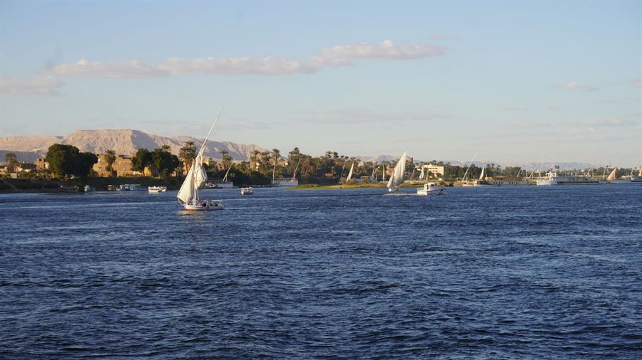 Sailboats on the Nile at sunset below desert hills